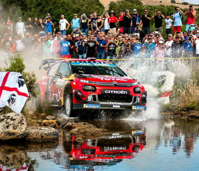Un'auto da rally WRC (Hyundai) sfreccia a tutta velocità su uno sterrato in Sardegna durante il WRC Sardegna 2026 ad Alghero, sollevando una nuvola di polvere.