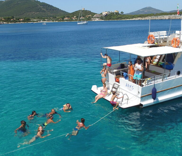 Gruppo di persone che fa il bagno durante un'escursione in barca ad Alghero con Ares Turismo.