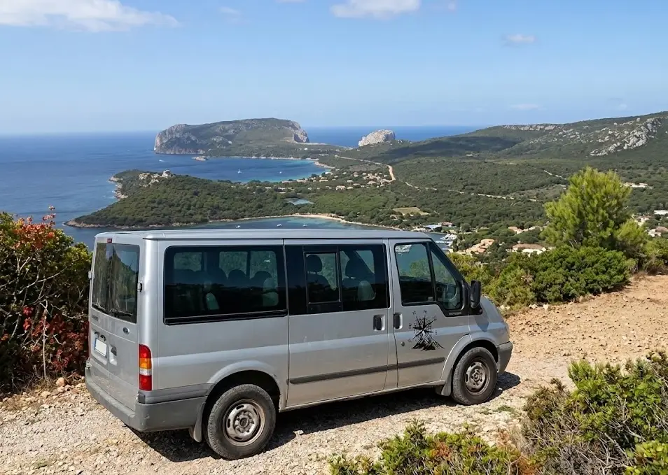 Veduta ravvicinata delle antiche torri in pietra calcarea e arenaria del Nuraghe Palmavera ad Alghero, circondate dai resti del villaggio di capanne sotto un cielo azzurro.